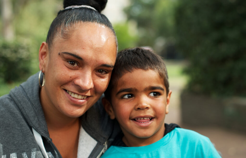 Australian aboriginal woman with male child outdoors