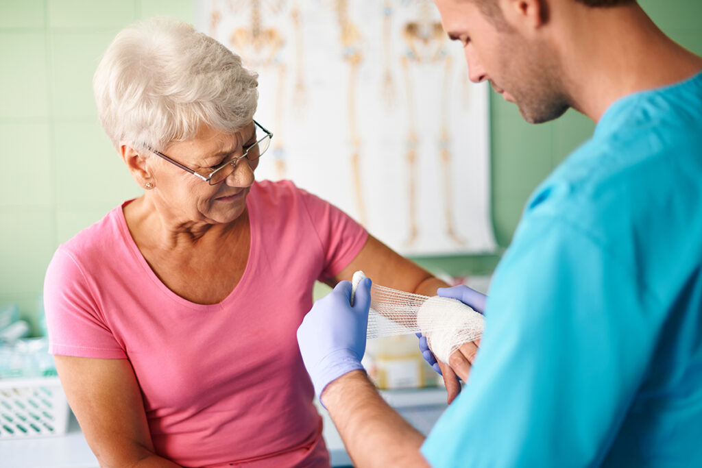Older lady having her wrist bandaged