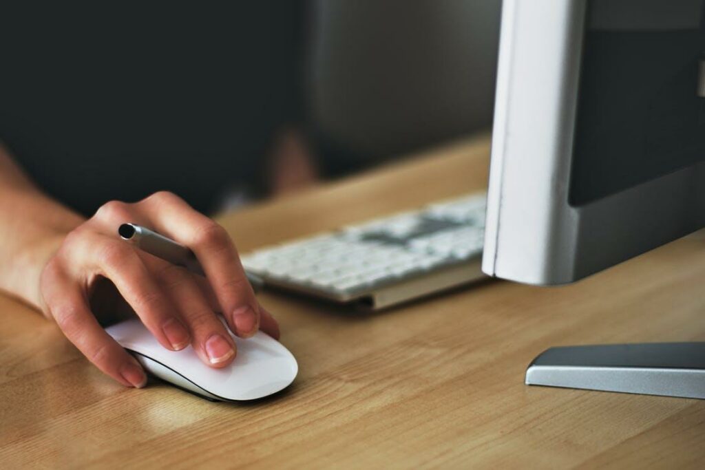 Hand operating computer mouse on desk