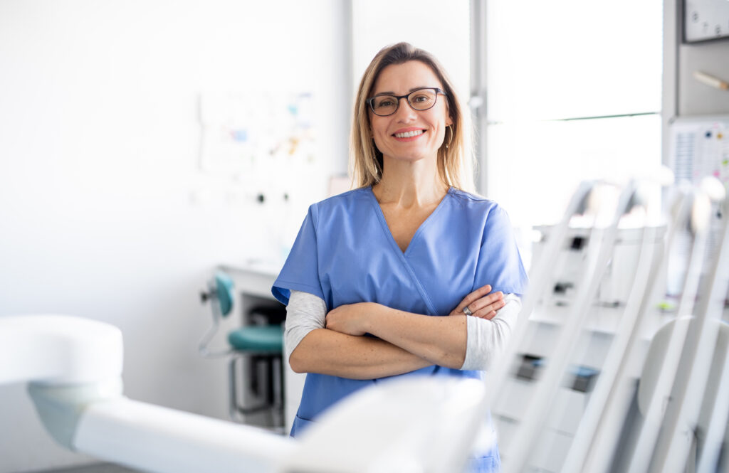 Smiling female doctor looking at the camera wearing blue scrubs