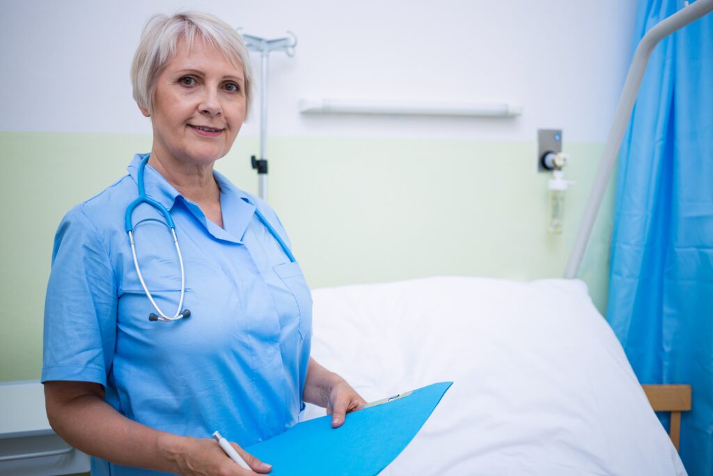 Olders health professional holding a folder in a treatment room