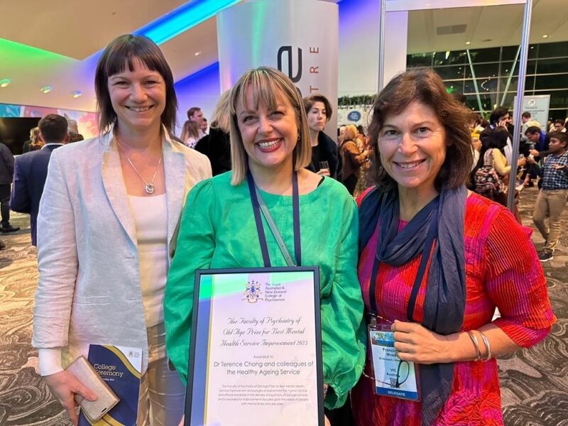 Three women standing and holding an award