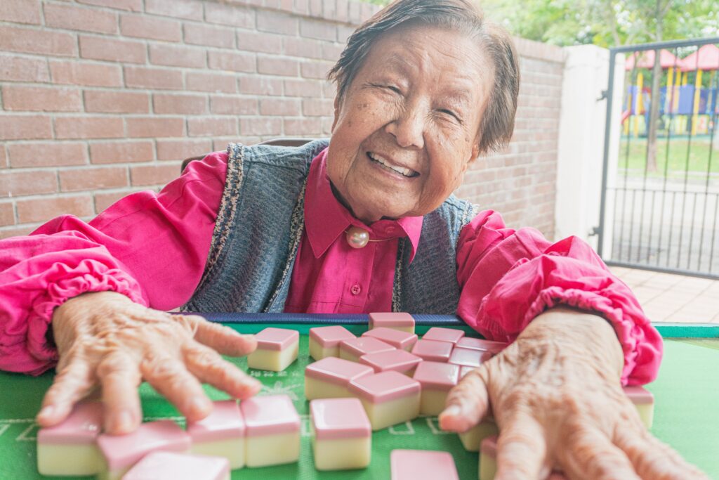 Elderly asian lady playing mahjong
