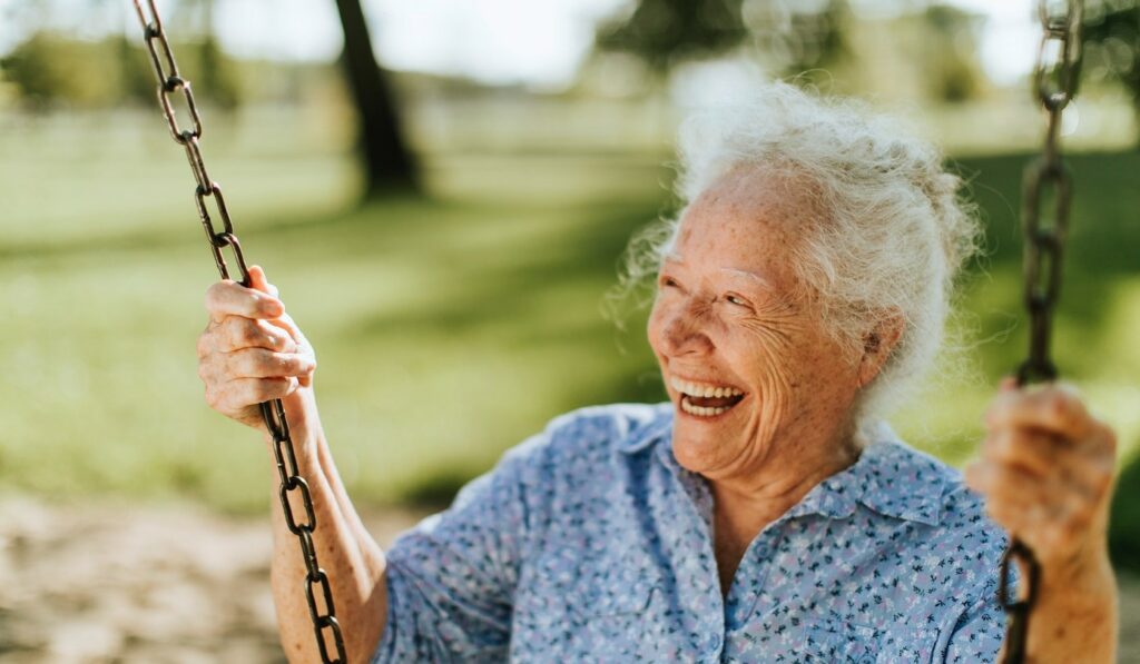 Elderly lady on a swing smiling