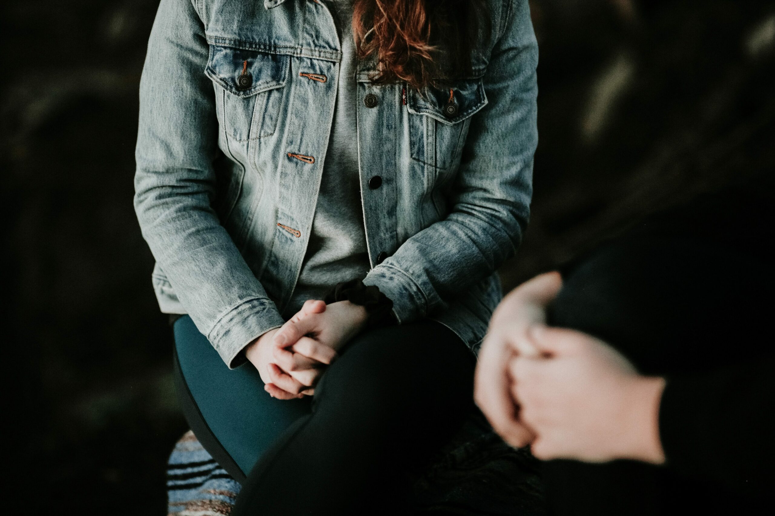 Two people seated talking but their faces are not visible