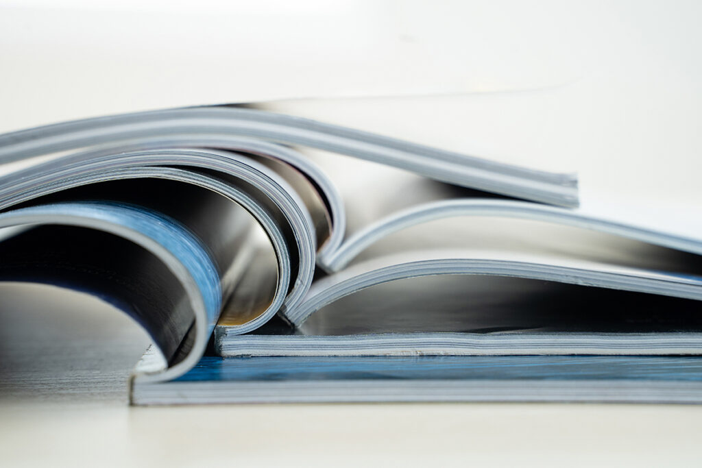 Image of a stack of magazine like books open at spine