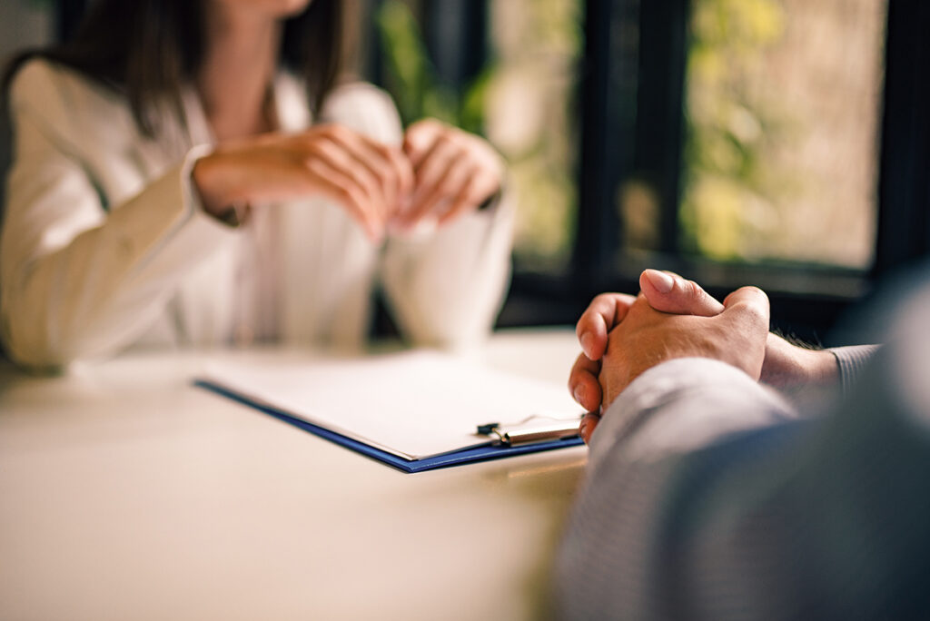 Two people sitting opposite each other over a document